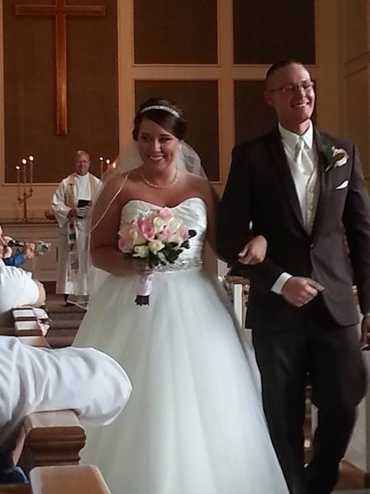 bride and groom walking down the aisle smiling
